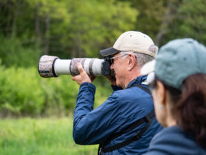 A visitor photographing birds using a camera with a long lens.