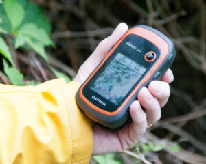 Geocaching: A hand holding geolocation device.