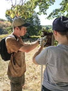 Two volunteers opening and cleaning out bluebird nexting boxes in the fall